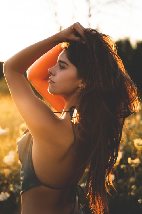 Free Captivating portrait of a young woman outdoors in natural light during golden hour. Stock Photo