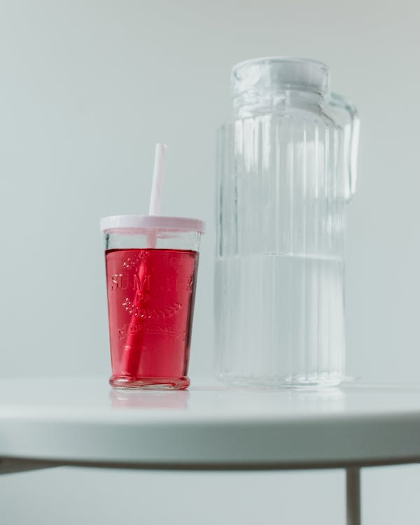 Cup Filled With Red Substance Beside Pitcher