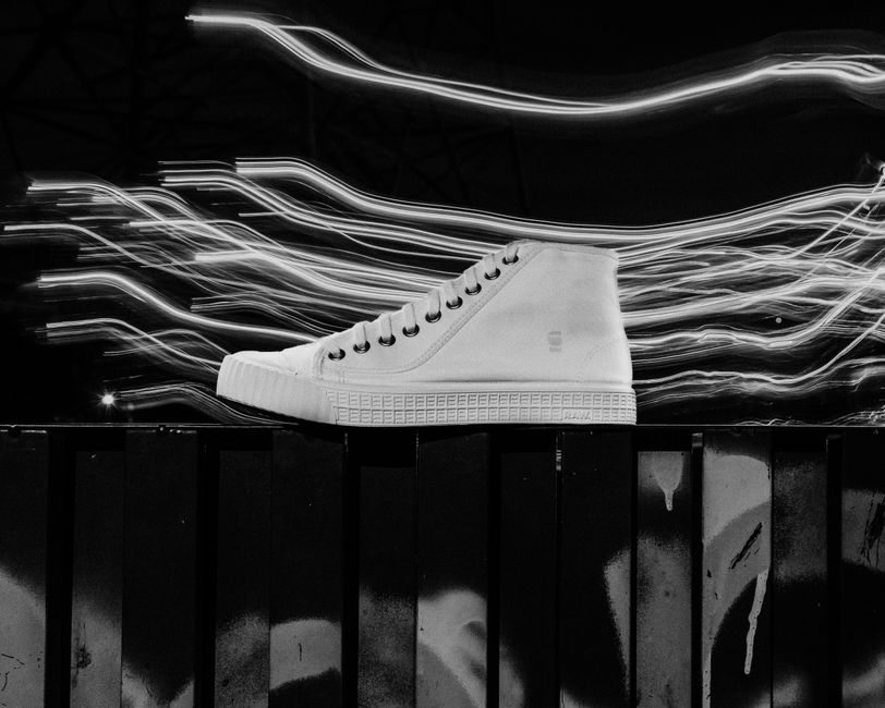Artistic photo of a shoe with dynamic light streaks in black and white.