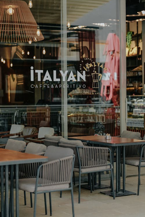 Wooden Tables with Chairs Beside the Glass Window