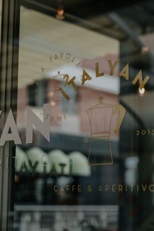 Free Close-up of elegant glass signage at an Italian cafe, showcasing reflections and text. Stock Photo