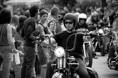 Grayscale Photo of Man Riding a Motorcycle