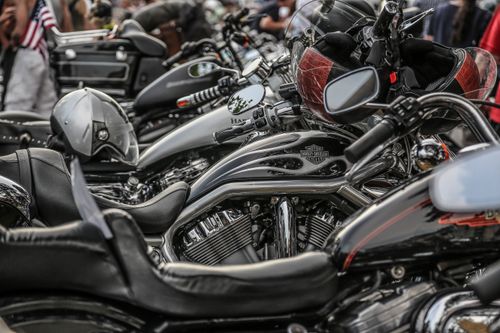 Free Close-up of stylish parked motorcycles in line, featuring helmets and chrome details at an outdoor event. Stock Photo