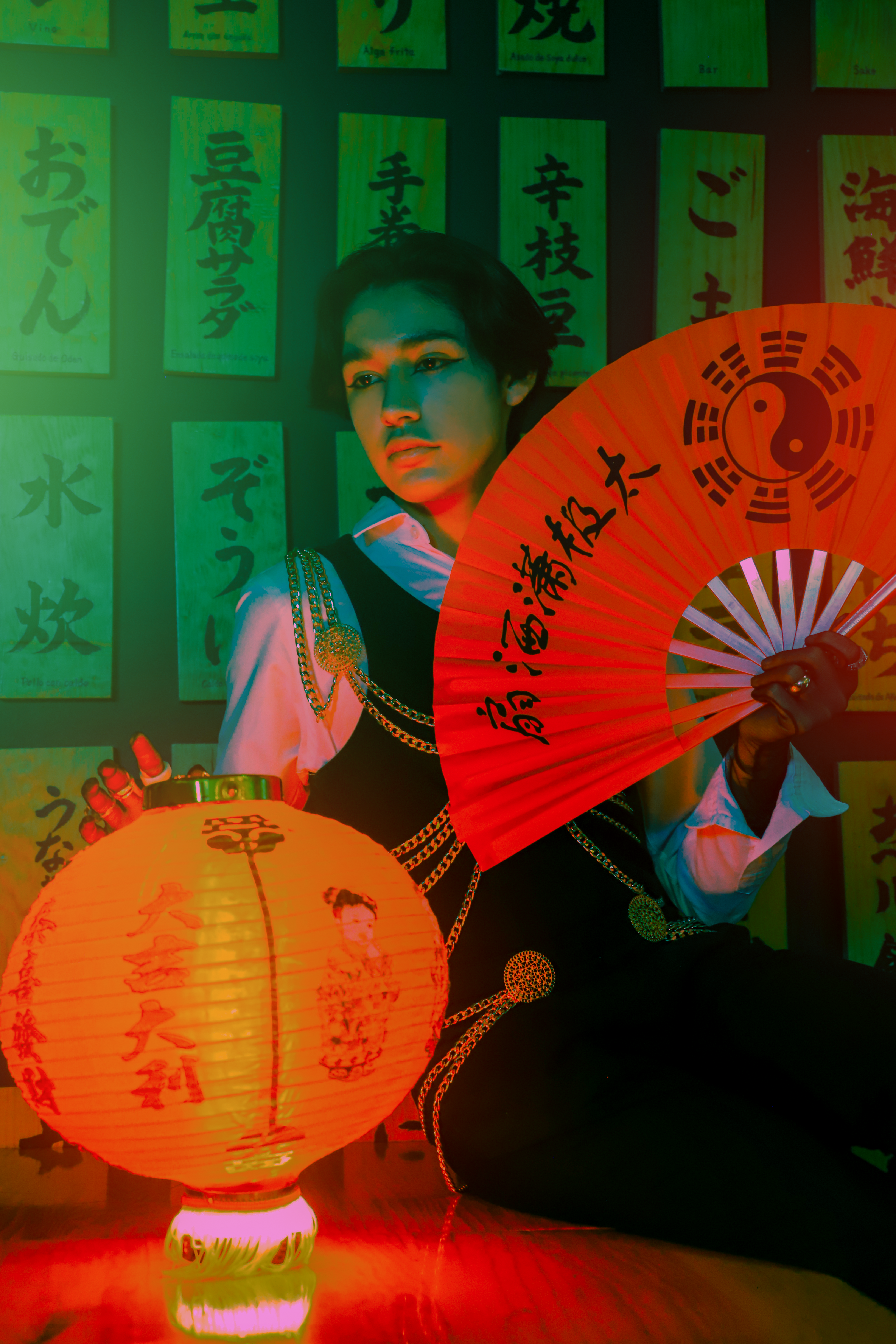 Vivid portrait featuring a person holding a lantern and fan against a wall with Asian characters.