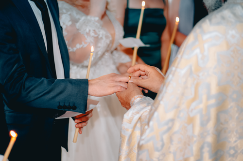 Free A couple exchanges rings during a traditional wedding ceremony in a church setting. Stock Photo