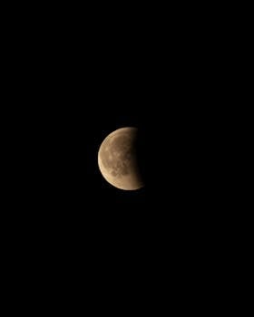 Half moon during a lunar eclipse with clear sky background, perfect for night sky enthusiasts.