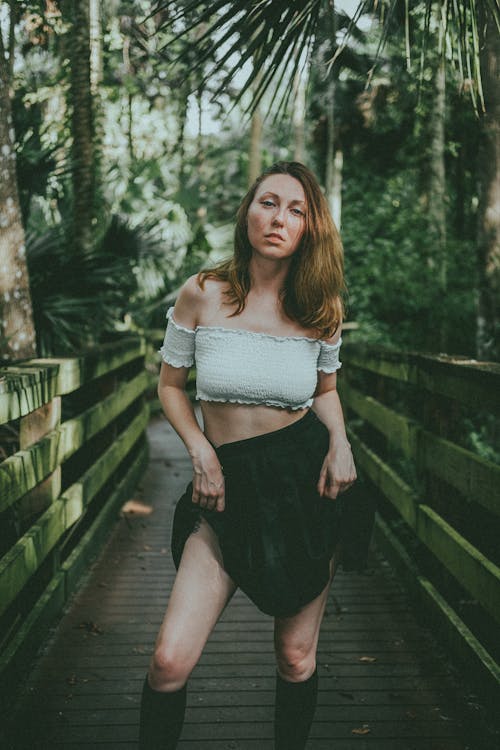 Woman in White Tube Top Posing on a Wooden Bridge