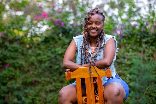 A  Woman in Denim Top Sitting on a Wooden Chair