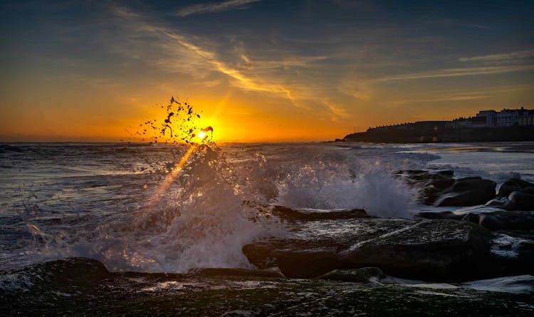 Waves Crashing On The Shore During Sunset