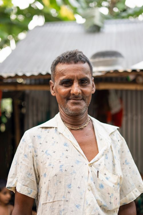 Free A candid portrait of a South Asian man wearing a gold necklace, captured outdoors in natural light. Stock Photo