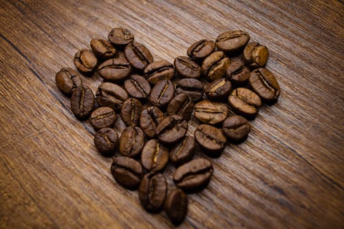 Free Close-Up Shot of Coffee Beans on a Wooden Surface Stock Photo