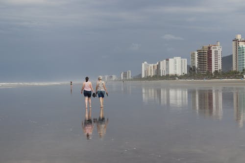 Free 2 Women in Bikini Standing on Beach Stock Photo