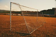 日落时，安静的足球场上有门柱，映出一种和平的气氛