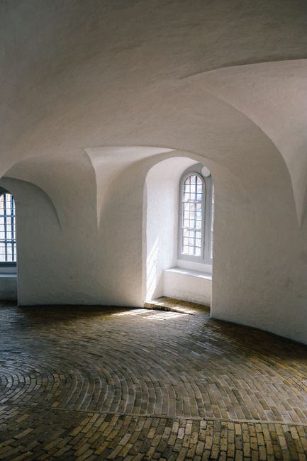 Explore the elegant curves and natural light in a historic brick interior.