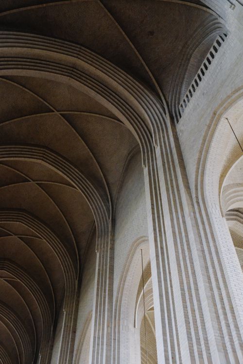 Free A stunning view of vaulted Gothic architecture showcasing ornate brickwork and archways in a cathedral. Stock Photo