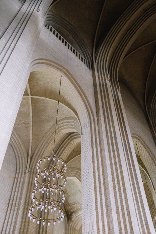 Free Elegant arches and chandelier inside Grundtvigs Church, Denmark. Stock Photo
