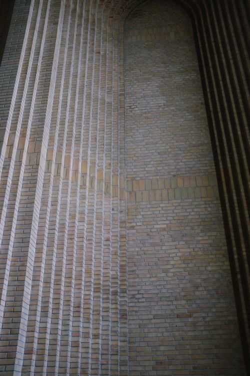 Free Vertical view of textured geometric brick wall in modern architectural design. Stock Photo