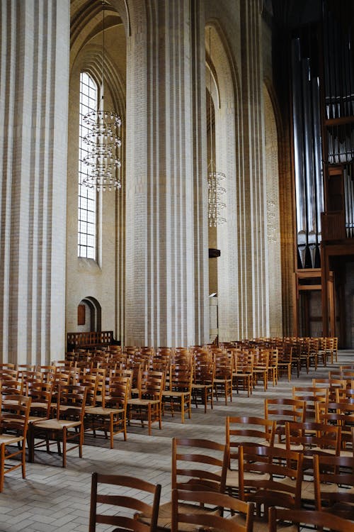Empty Neo Gothic Church with Rows of Wooden Chairs