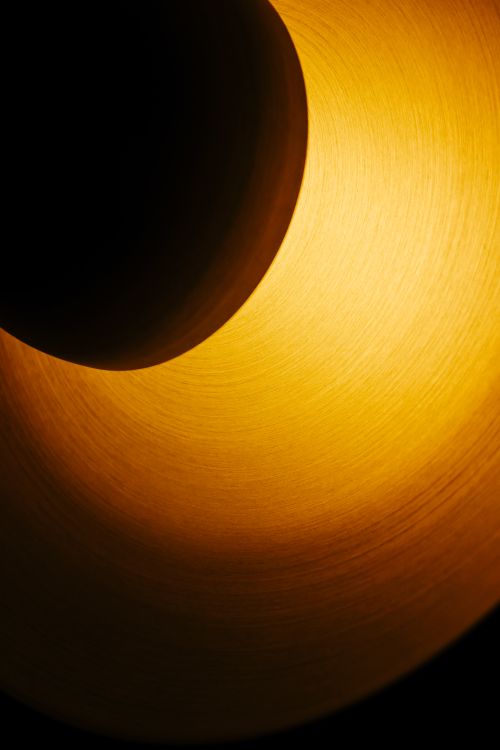 Free Dramatic abstract image depicting circular shadows and golden light patterns. Stock Photo