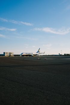 A Ryanair aircraft on the tarmac of an airport with clear blue skies.