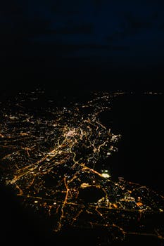 A breathtaking aerial view of a city illuminated at night, showcasing glowing streetlights and bustling streets.