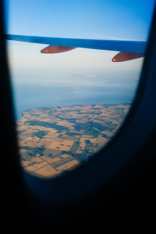 Free View of countryside and coastline from airplane window during flight. Stock Photo