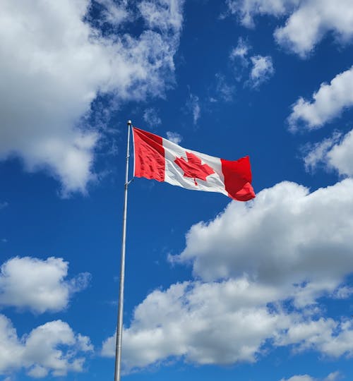 Canadian Flag Under Blue Skies