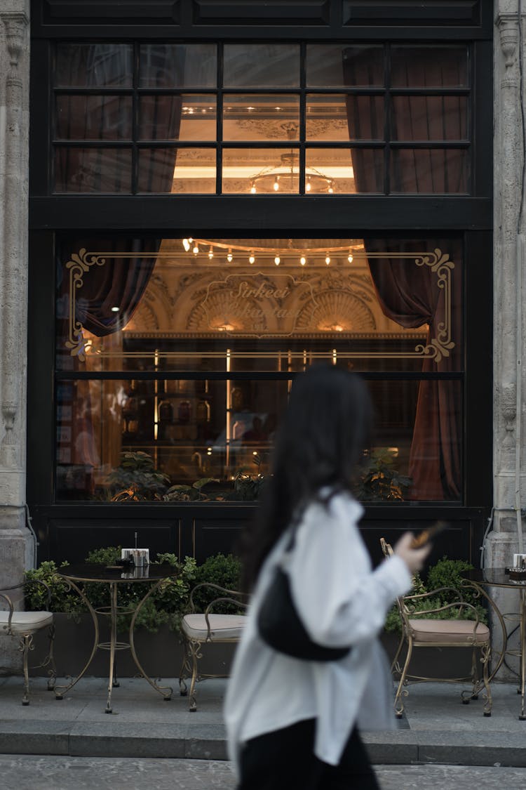 Woman Walking Past A Restaurant 