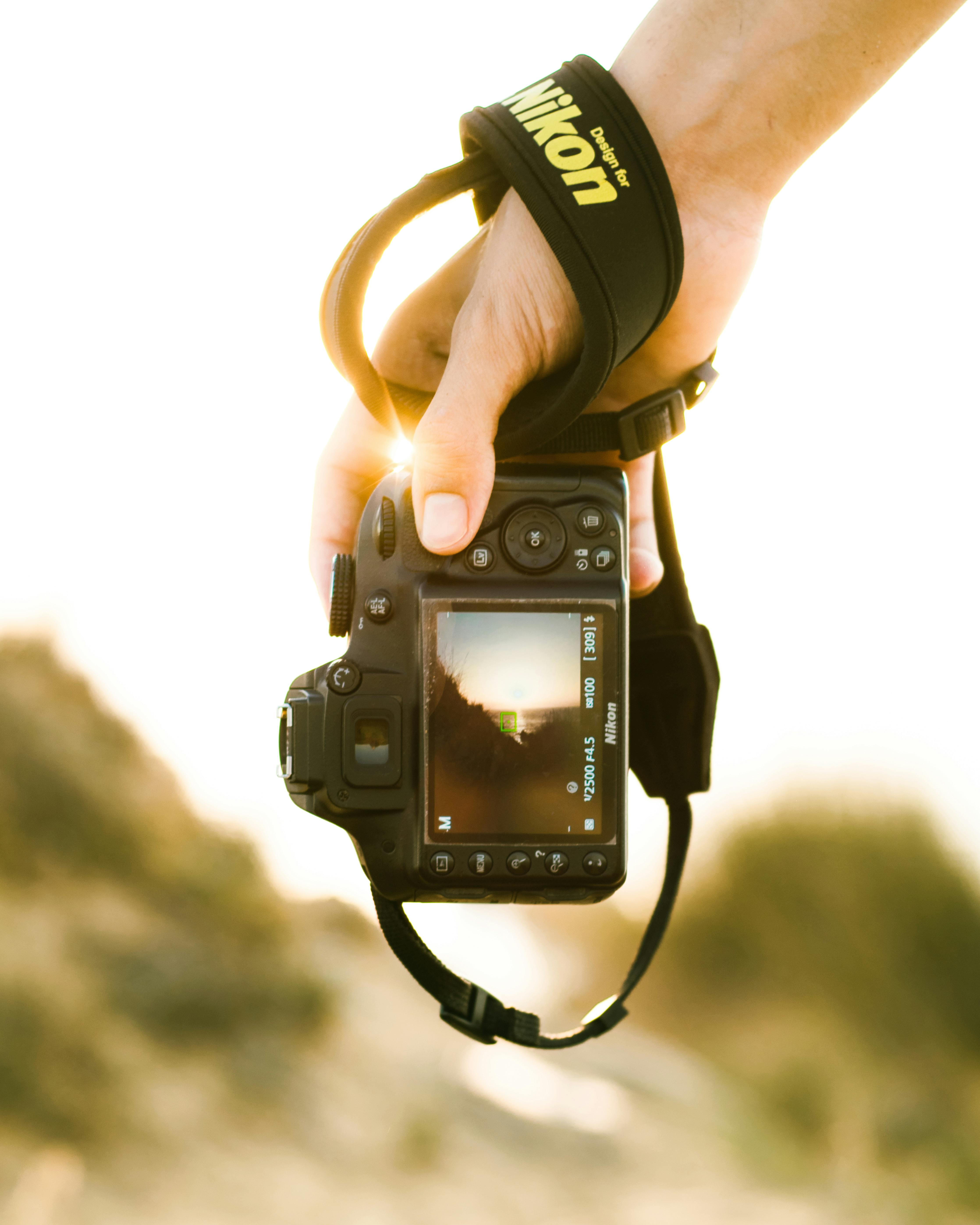 Free Close-up of a hand holding a camera at sunset in Mostaganem, Algeria. Stock Photo