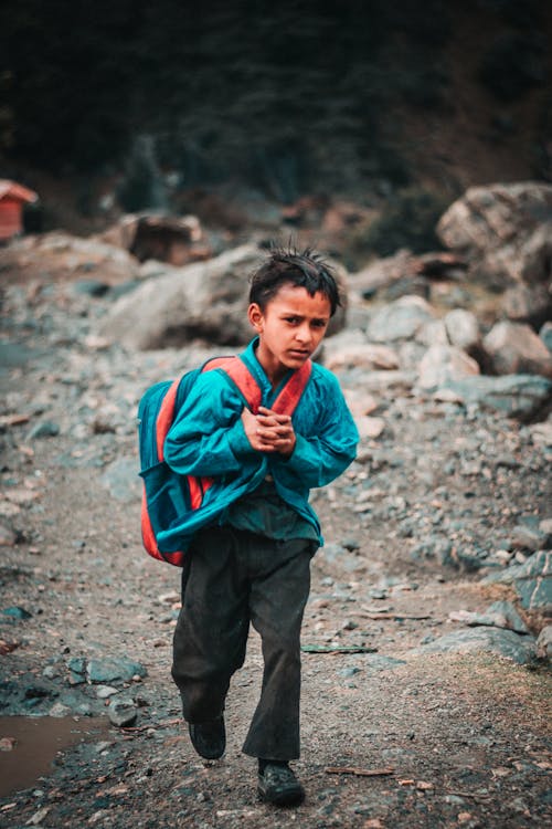 Boy in Blue Jacket Carrying a Backpack
