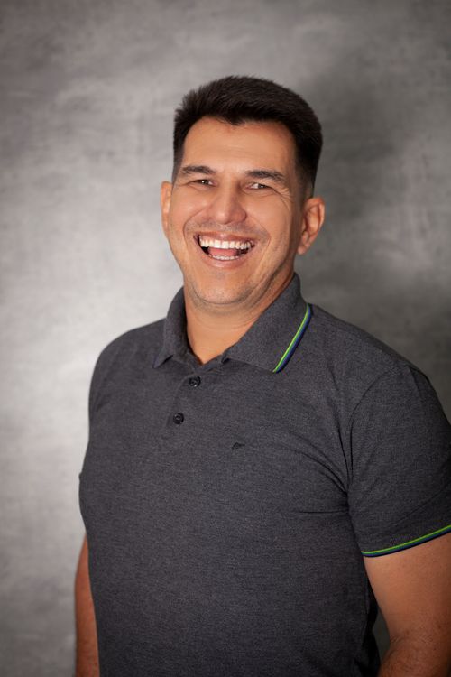 Free Portrait of a smiling man in a polo shirt against a studio backdrop. Stock Photo