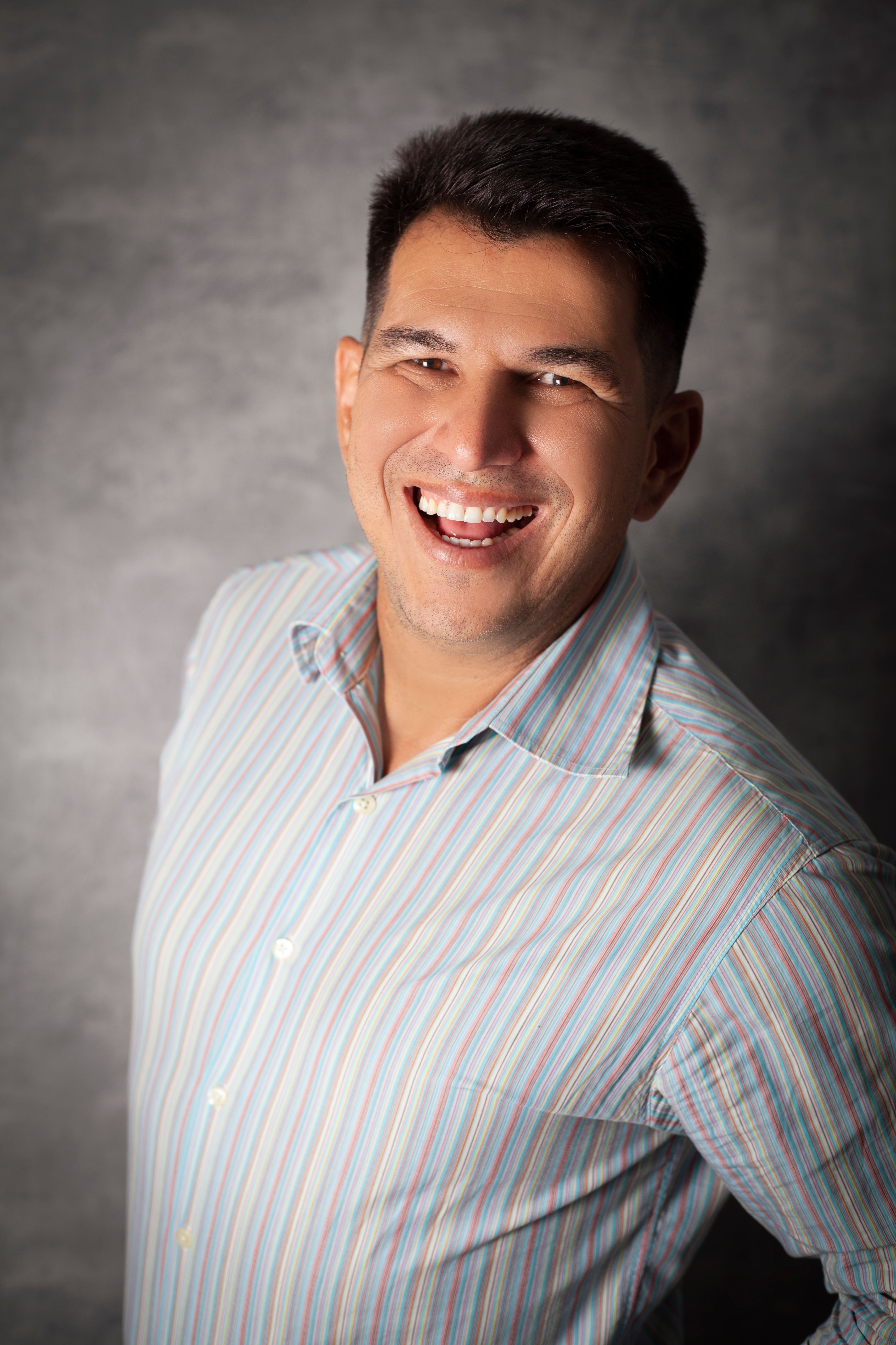 Portrait of a smiling man in stripes, exemplifying joy and positivity.