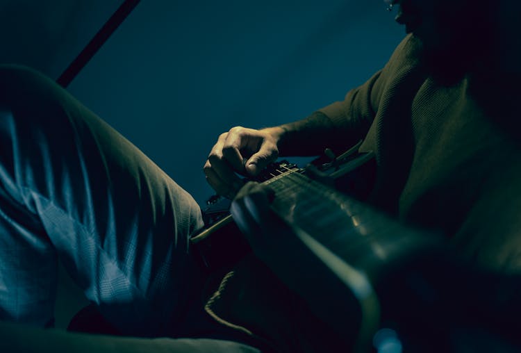 A Person Playing A Guitar