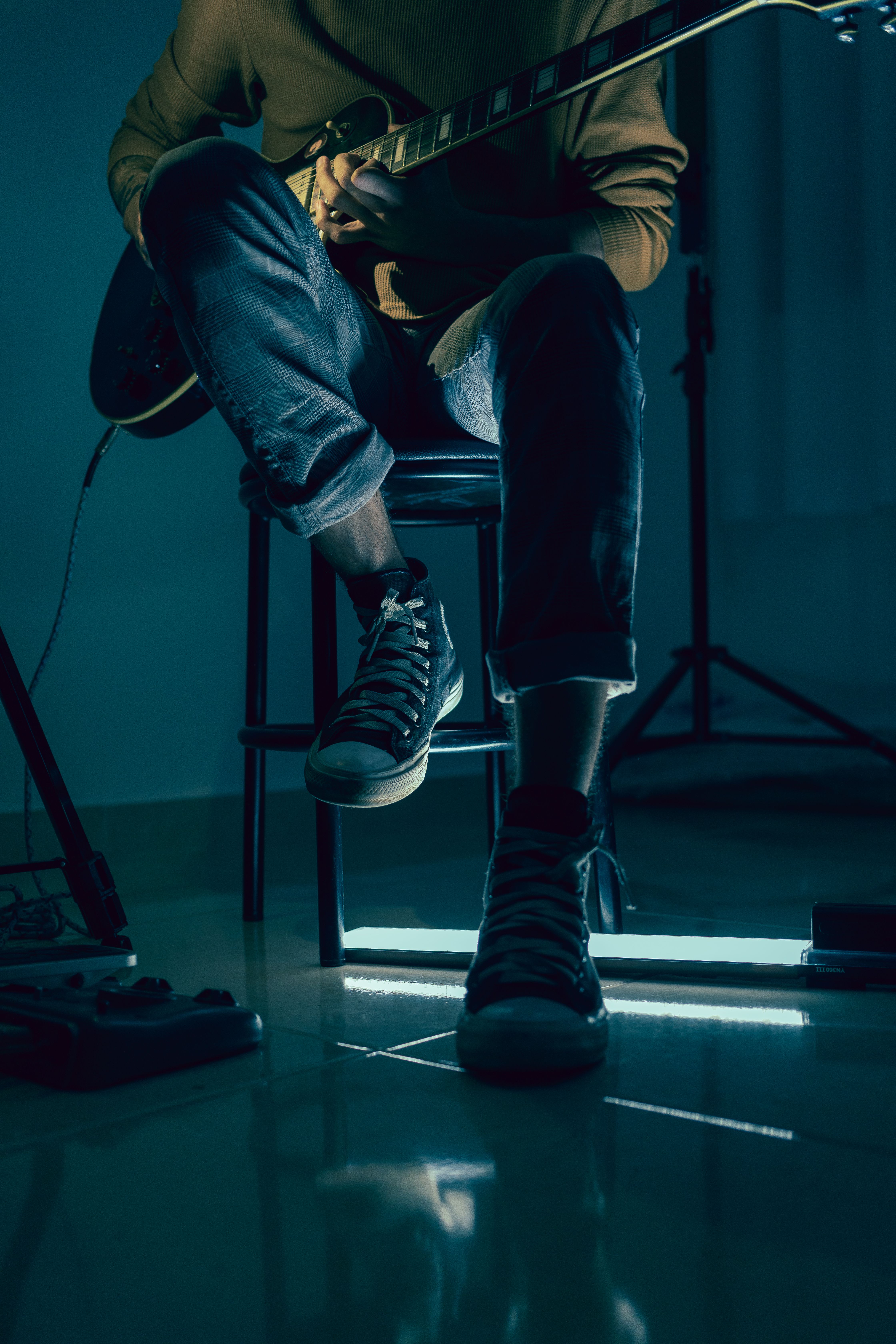 A Person Sitting on a Chair Playing Guitar · Free Stock Photo