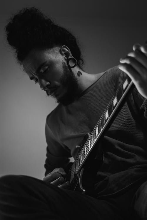 Grayscale Photo of a Man Playing the Electric Guitar 