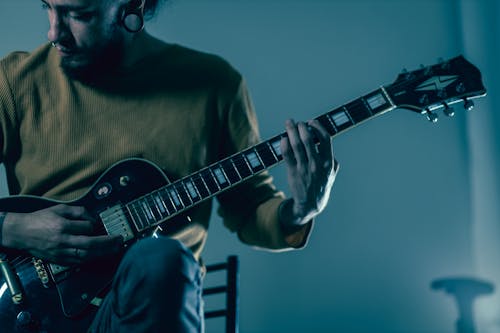 Close Up Photo of a Person Playing Electric Guitar