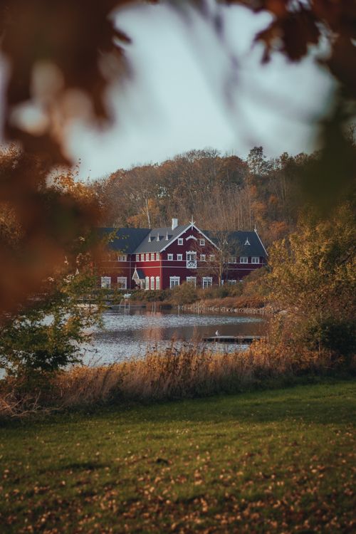 Free Scenic view of a Danish hotel by the lake surrounded by autumn foliage. Stock Photo