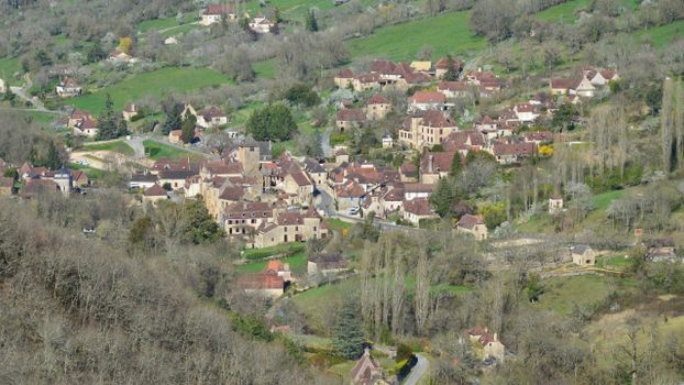 Aerial view of a picturesque French village nestled in lush countryside, showcasing charming architecture.