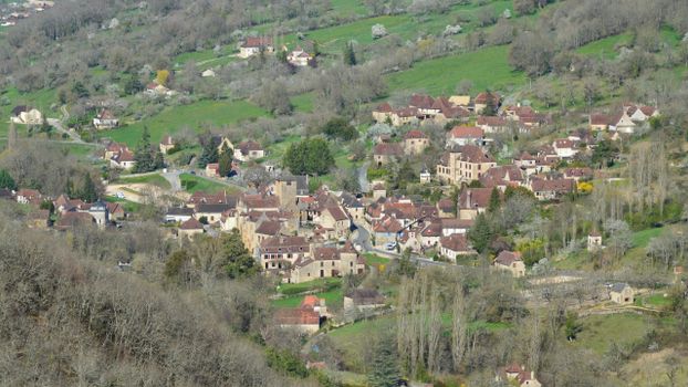 Charming aerial shot of a European village in lush greenery, showcasing rustic architecture.