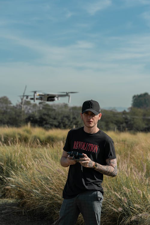 Man in Black Crew Neck Shirt Standing on Green Grass Field