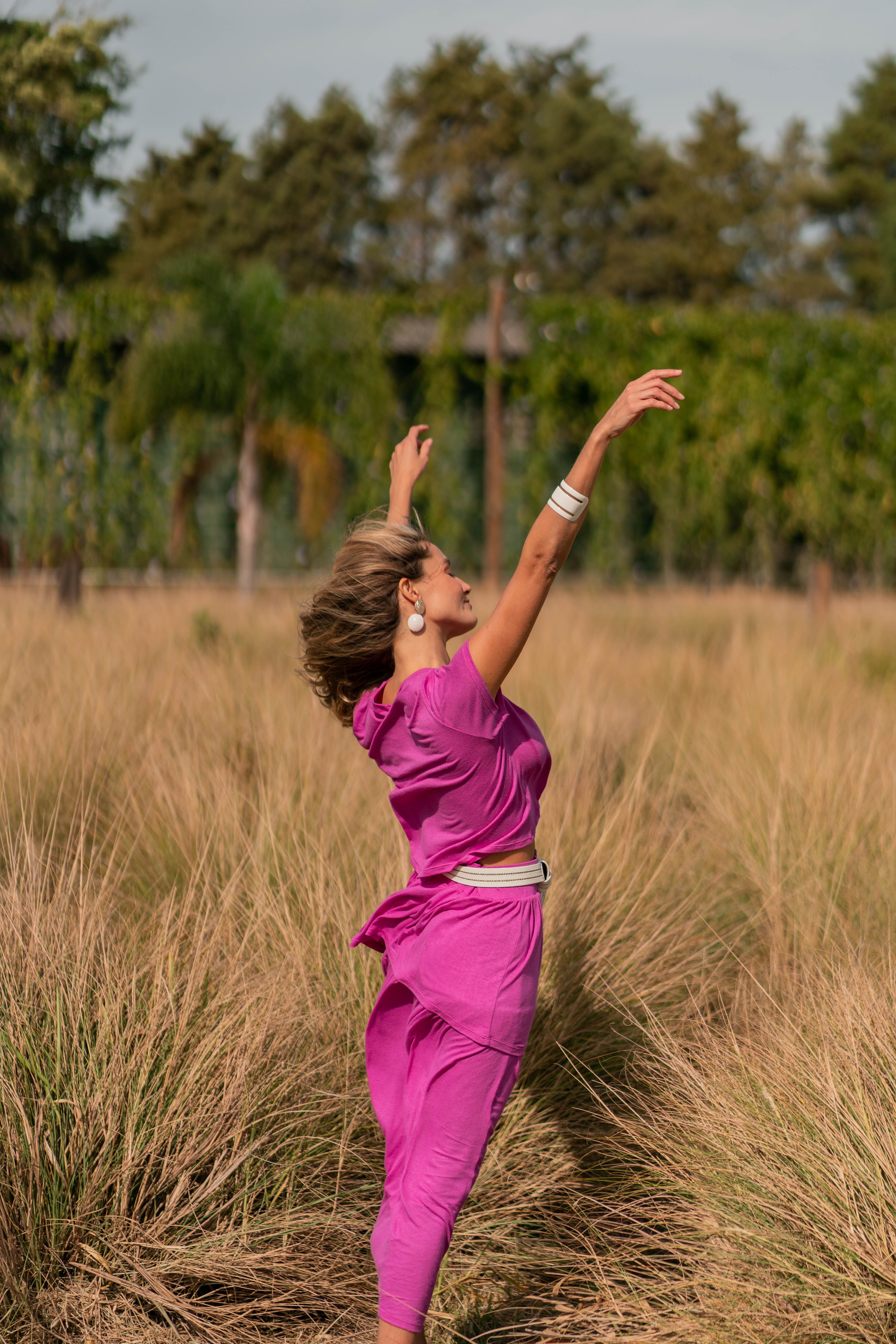 Woman in Pink Outfit Standing on Grass Field · Free Stock Photo