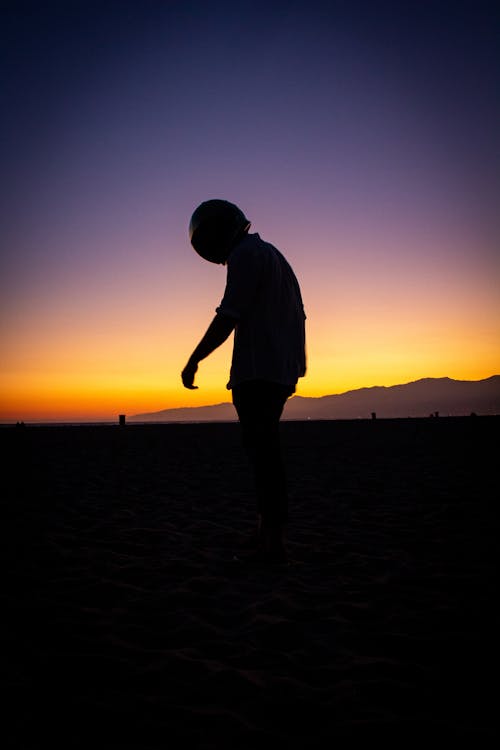 Silhouette of a Person Wearing Helmet during Sunset