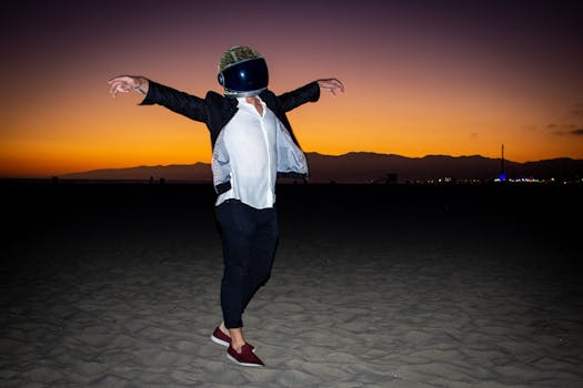 Silhouette of a person wearing a helmet, dancing at sunset on a sandy beach.