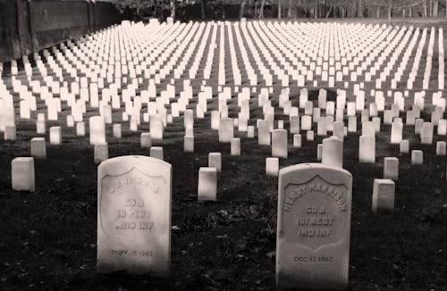 Grayscale Photo of Tombstones in a Cemetery