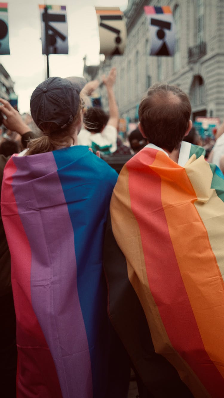 People Wrapped In Rainbow Flags