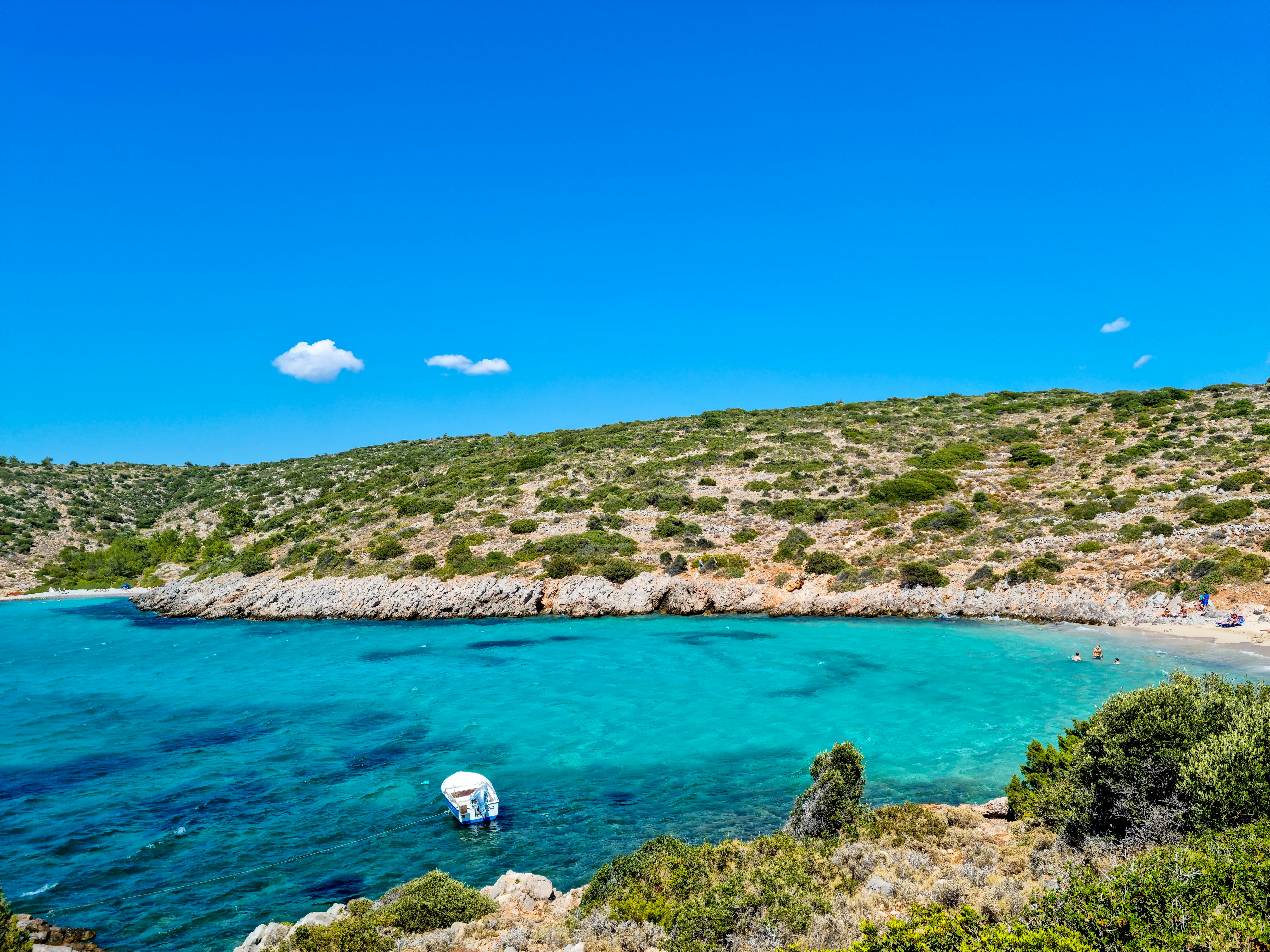 Capture of a serene Greek bay with turquoise waters and lush greenery, perfect for travel enthusiasts.