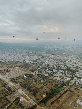 Stunning aerial view of hot air balloons floating over San Juan Teotihuacán, showcasing the vast landscape.