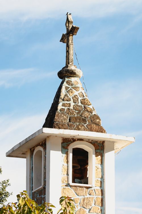 Free Stone church tower with a cross against a blue sky in San Francisco, Argentina. Stock Photo
