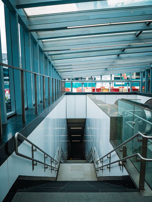 Free Bright subway entrance with a sleek glass roof and descending stairs. Stock Photo