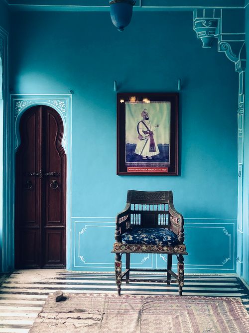 Free Elegant room featuring a vintage chair and traditional art in a vibrant setting. Stock Photo